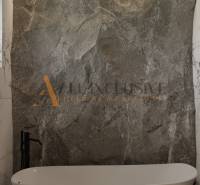 POSLEDNÁ NOVOSTAVBA - HOLODOM | PRÁZNOVCE - Elegantná kúpeľňa s vaňou a kamennou stenou v rodinnom dome.