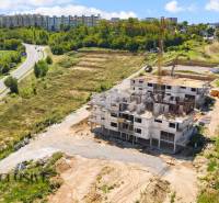 1i - 2i - 3i BYTY V NOVOSTAVBE | NITRA - MLYNARCE - Stavenisko na Kmeťovej ulici v Nitre obklopené zeleňou a výškovými budovami.