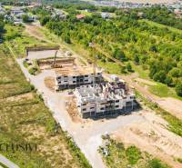 1i - 2i - 3i BYTY V NOVOSTAVBE | NITRA - MLYNARCE - Stavenisko bytového komplexu na Kmeťovej ulici v Nitre obklopené zeleňou a domami.