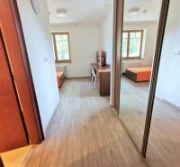 PEKNÁ GARSÓNKA, NOVOSTAVBA, KLÍMA, DRAŽDIAK HAUS, Antolská ulica - Garsónka s podlahou s dreveným dekorom, veľkým oknom a pracovným stolom.