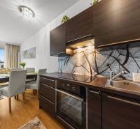 KRÁSNY 2i byt, KLÍMA, LOGGIA,VÝHĽAD,PANORAMA CITY, Landererova ulica - Kuchynský kút v 2-izbovom byte s podlahou s dreveným dekorom a jedálenským stolom.