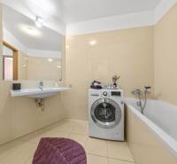 KRÁSNY 2i byt, KLÍMA, LOGGIA,VÝHĽAD,PANORAMA CITY, Landererova ulica - Kúpeľňa s vaňou, umývadlom a práčkou v 2-izbovom byte, béžová dlažba.