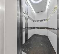 KRÁSNY 2i byt, KLÍMA, LOGGIA,VÝHĽAD,PANORAMA CITY, Landererova ulica - Interiér výťahu s bielymi panelmi a kovovými prvkami v 2-izbovom byte.