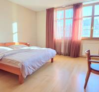 VEĽKOMETRÁŽNY 3i byt, 3 x NEPRIECHODNÁ IZBA, KLÍMA, BALKÓN, Nám.SNP - Svetlá spálňa s podlahou s dreveným dekorom, manželskou posteľou a pracovným stolom v 3-izbovom byte.