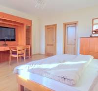 VEĽKOMETRÁŽNY 3i byt, 3 x NEPRIECHODNÁ IZBA, KLÍMA, BALKÓN, Nám.SNP - Svetlá spálňa v 3-izbovom byte s dreveným nábytkom, TV a podlahou s dreveným dekorom.