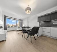 ŠTÝLOVÝ 2i byt,SKY PARK,VÝHĽAD,LOGGIA,PARKING,VEŽA II,Továrenská ul. - Kuchyňa s jedálenským stolom, pohovkou, televízorom a podlahou s dreveným dekorom v 2-izbovom byte.