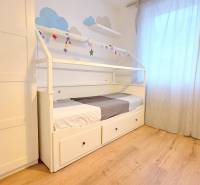 LUXUSNÝ 3i byt, TERASA, PARKING, KLÍMA, ZELENÁ HORKA, Ďumbierska ulica - Detská izba s posteľou, šatníkom a podlahou s dreveným dekorom v 2-izbovom byte.