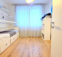 LUXUSNÝ 3i byt, TERASA, PARKING, KLÍMA, ZELENÁ HORKA, Ďumbierska ulica - Detská izba s posteľou, podlahou s dreveným dekorom a policovým regálom v 2-izbovom byte.