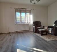 Šikovná drevenica pod lesom Slovenské Pravno  - Obývacia izba s kreslami a podlahou s dreveným dekorom v rodinnom dome.