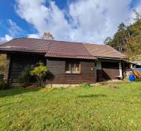 Šikovná drevenica pod lesom Slovenské Pravno  - Rodinný dom v Slovenskom Pravne so šikmou strechou a drevenou fasádou.