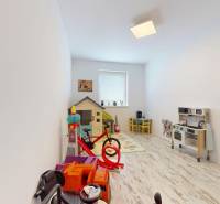 4-izbový byt 92m2 + terasa 14m2 | Bernolákovo - Detská izba v 4-izbovom byte s hračkami a podlahou s dreveným dekorom.