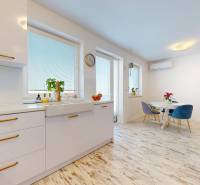 4-izbový byt 92m2 + terasa 14m2 | Bernolákovo - Kuchyňa v 4-izbovom byte s podlahou s dreveným dekorom, stolom a rastlinami.