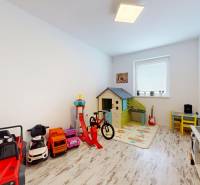 4-izbový byt 92m2 + terasa 14m2 | Bernolákovo - Detská izba v 4-izbovom byte so svetlom, podlahou s dreveným dekorom a hračkami.