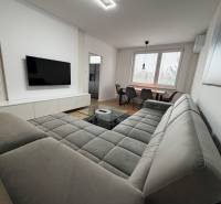 3 izbový byt s balkónom Topoľčany / PRENAJOM  - Obývací priestor v 3-izbovom byte s pohovkou, TV a jedálenským stolom, podlaha s dreveným dekorom.