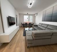 3 izbový byt s balkónom Topoľčany / PRENAJOM  - Svetlá obývačka v 3-izbovom byte s pohovkou a podlahou s dreveným dekorom.