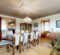 Na predaj Rodinný dom -rezort - Banská Bystrica 4500m2 - Jedáleň v rodinnom dome s dreveným jedálenským stolom, klavírom a vkusnými dekoráciami.