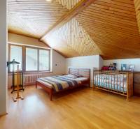 Na predaj Rodinný dom -rezort - Banská Bystrica 4500m2 - Podkrovná izba v rodinnom dome s dreveným stropom, detskou postieľkou a posteľou.
