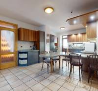 Na predaj Rodinný dom -rezort - Banská Bystrica 4500m2 - Kuchyňa v rodinnom dome s dreveným nábytkom, jedálenským stolom a keramickou dlažbou.