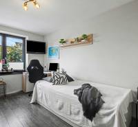 Ideálny dom pre rodinu, Blatné, okr. Senec - Izba v rodinnom dome s podlahou s dreveným dekorom, posteľou a pracovným stolom.