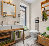 Ideálny dom pre rodinu, Blatné, okr. Senec - Kúpeľňa v rodinnom dome s dvomi umývadlami, zrkadlom, drevenou skrinkou a dekoráciami.