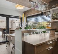 Ideálny dom pre rodinu, Blatné, okr. Senec - Kuchyňa v rodinnom dome s podlahou s dreveným dekorom a výhľadom na terasu.