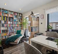 Ideálny dom pre rodinu, Blatné, okr. Senec - Domáca knižnica s pohodlným kreslom a stolíkom, obklopená rastlinami a knihami.