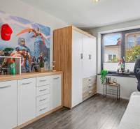 Ideálny dom pre rodinu, Blatné, okr. Senec - Detská izba v Rodinnom dome s podlahou s dreveným dekorom a komiksovou tapetou.