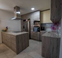 ATRAKTÍVNY 2 IZBOVÝ BYT S VLASTNOU ZÁHRADKOU a 3 parkovacími miestami - Kuchyňa v 2-izbovom byte s kútom, skriňami a spotrebičmi, podlaha s dreveným dekorom.