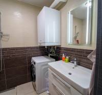 ATRAKTÍVNY 2 IZBOVÝ BYT S VLASTNOU ZÁHRADKOU a 3 parkovacími miestami - Kúpeľňa v 2-izbovom byte s práčkou, sprchovacím kútom a umývadlom so skrinkou.