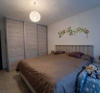 ATRAKTÍVNY 2 IZBOVÝ BYT S VLASTNOU ZÁHRADKOU a 3 parkovacími miestami - Spálňa v 2-izbovom byte s veľkou posteľou, vstavanou skriňou a detskými dekoráciami.