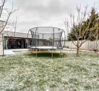 Unikátna 4i NOVOSTAVBA, Špačince 740m² pozemok len pár minút od Trnavy - Rodinný dom v Trnave so záhradou, trampolínou a holými stromami, pokrytými jemnou vrstvou snehu.