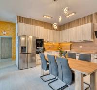 Unikátna 4i NOVOSTAVBA, Špačince 740m² pozemok len pár minút od Trnavy - Kuchyňa v rodinnom dome s podlahou s dreveným dekorom a zaujímavým osvetlením.