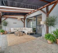 Unikátna 4i NOVOSTAVBA, Špačince 740m² pozemok len pár minút od Trnavy - V Trnave pri rodinnom dome terasa s pohovkou, stolíkmi a rastlinami vo kvetináčoch.