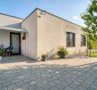 Unikátna 4i NOVOSTAVBA, Špačince 740m² pozemok len pár minút od Trnavy - Rodinný dom v Trnave s terasou, dlažbou, dvoma plastovými stoličkami a kvetinami.