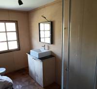 Na predaj záhradná chatka - Kúpeľňa v chate s umývadlom, sprchovacím kútom a podlahou s dreveným dekorom.