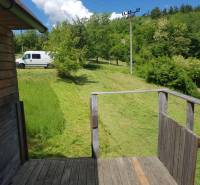 Na predaj záhradná chatka - Drevená terasa chaty v Žarnovici na ulici Na Gremenici, s výhľadom na zelený dvor.