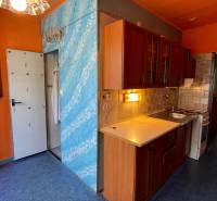Na predaj veľký 3-izbový byt s lodžiou v Detve - Novosady - Kuchyňa v 3-izbovom byte s pestrými stenami, drevenými skrinkami a keramickým obkladom.