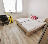 2 - izbový byt - 54 m², Hamuliakovo, internet v cene ! - Svetlá spálňa v 2-izbovom byte s posteľou, pracovným stolom a podlahou s dreveným dekorom.