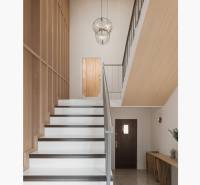 Dvojgeneračný rodinný dom s potenciálom | 2 bytové jednotky, TV - Schodisko v rodinnom dome s dreveným obkladom, svietidlá a dekoratívny stôl na chodbe.