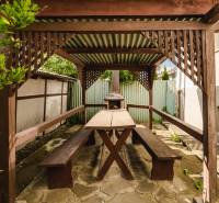 Dvojgeneračný rodinný dom s potenciálom | 2 bytové jednotky, TV - Drevený prístrešok s posedením v záhrade rodinného domu na SNP ulici v Trebišove.