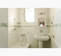 Dvojgeneračný rodinný dom s potenciálom | 2 bytové jednotky, TV - Kúpeľňa v rodinnom dome s vaňou, umývadlom a zrkadlom, obkladaná svetlými dlaždicami.