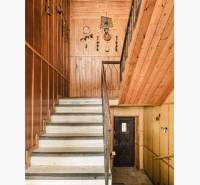 Dvojgeneračný rodinný dom s potenciálom | 2 bytové jednotky, TV - Schodisko v rodinnom dome s drevenými dekoráciami a dreveným obložením na stenách.