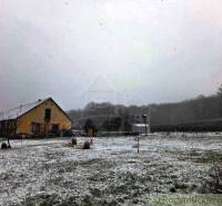 27130m2 samota obklopená lesom - Šalov, okres Levice - Zasnežená chata v Šalove na rozľahlej lúke obklopenej stromami v zime.