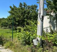 NA PREDAJ stavebný pozemok pod Zoborom ‼️znizena cena - Na obrázku je úzka cesta s elektrickým stĺpom obklopená zeleňou a plotom.