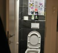 Veľký 2-izb. byt v tehlovom dome, Ružová dolina, Ružinov časť Nivy - Toaleta v 2-izbovom byte s tmavými obkladmi a bežným vybavením.