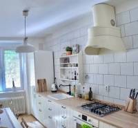 Veľký 2-izb. byt v tehlovom dome, Ružová dolina, Ružinov časť Nivy - Kuchyňa s podlahou s dreveným dekorom a bielym nábytkom v 2-izbovom byte.