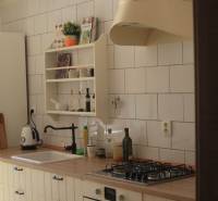 Veľký 2-izb. byt v tehlovom dome, Ružová dolina, Ružinov časť Nivy - Kuchyňa v 2-izbovom byte s bielou dlažbou, dreveným dekorom a plynovým sporákom.