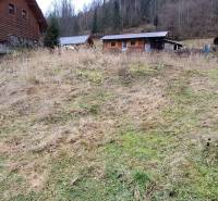 Lukratívny stavebný pozemok - Pozemok na bývanie v Oščadnici obklopený drevenými stavbami a lesom.