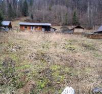 Lukratívny stavebný pozemok - Pozemok na bývanie v Oščadnici, s drevenicou a lesnou kulisou v pozadí.