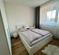 Novostavba FUXOVA 2 izbový byt, parking, Bosákova ul., BA V. Petržalka - Spálňa so svetlým zariadením, podlahou s dreveným dekorom a oknom v 2-izbovom byte.